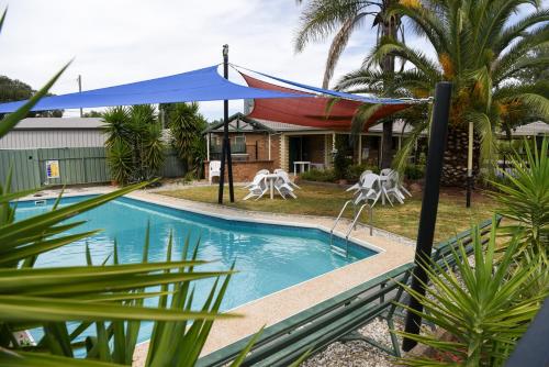a pool in front of a house with a blue tent at Culcairn Motor Inn in Culcairn