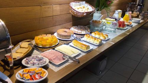 a table topped with lots of different types of food at San Diego Lancaster Teófilo Otoni in Teófilo Otoni