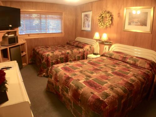a hotel room with two beds and a tv at Giant Oaks Lodge in Running Springs