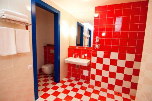 a red and white tiled bathroom with a sink at Road Star Hotel in Dnipro