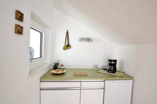 uma cozinha com um balcão verde e uma janela em Ferienwohnung Monika Knoflach em Innsbruck
