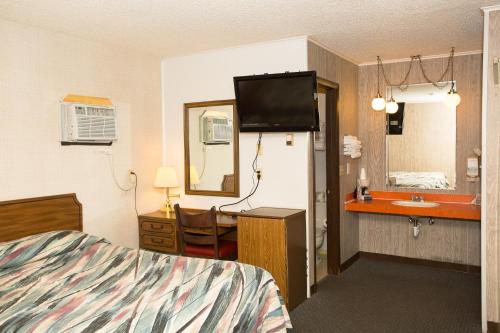 een hotelkamer met een bed en een wastafel bij Z Bar Motel in Buffalo