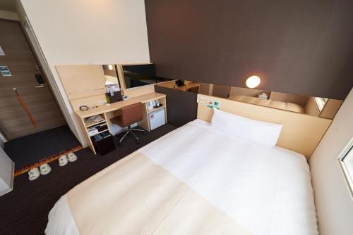 a bedroom with a large bed and a desk at Super Hotel JR Nara Ekimae Sanjo Dori in Nara
