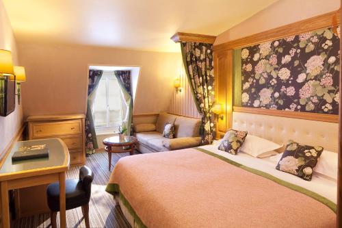 Habitación de hotel con cama y escritorio en La Perle en París