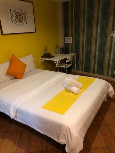 a bedroom with a large bed with towels on it at VX The Fifty in Bangkok