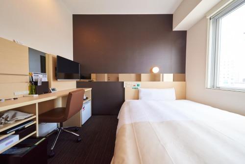 Cette chambre comprend un lit et un bureau. dans l'établissement Super Hotel JR Nara Ekimae Sanjo Dori, à Nara