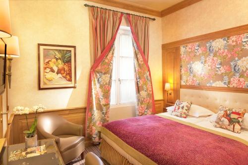 une chambre avec un lit, une fenêtre et une chaise dans l'établissement La Perle Saint Germain des Prés, à Paris