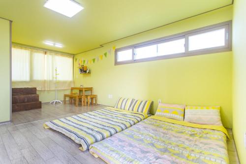 a bedroom with two beds and a window at 오후여섯시펜션 in Jeju