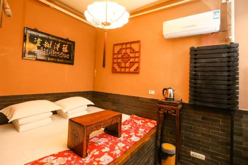Habitación con 2 camas, mesa y ventilador. en Pingyao Zheng Garden Inn, en Pingyao