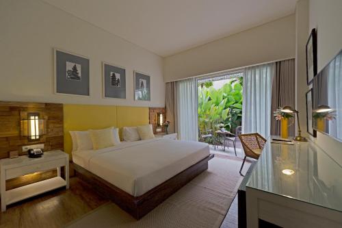 Un pat sau paturi într-o cameră la Bali Paragon Resort Hotel