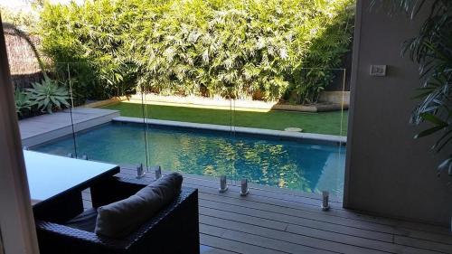 a patio with a table and chairs and a swimming pool at Sols Place Boutique Pool Villas in Kalbarri
