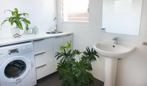 a bathroom with a washing machine and a sink at Sols Place Boutique Pool Villas in Kalbarri