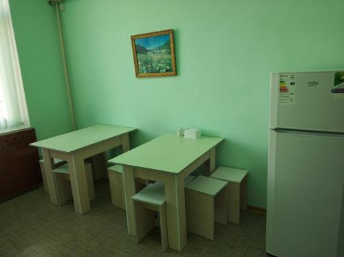 a kitchen with two tables and a refrigerator at Элем-Т in Aktau