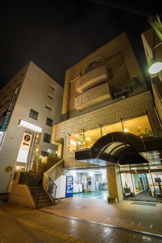 a large building with an archway in front of it at Hotel Sun Garden Matsuyama in Matsuyama