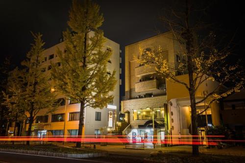 a building with trees in front of it at night at Hotel Sun Garden Matsuyama in Matsuyama