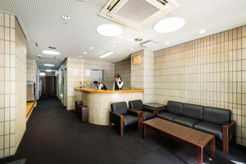 a woman standing at a bar in a waiting room at Hotel Sun Garden Matsuyama in Matsuyama