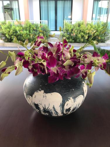 a black and white vase with flowers in it at Aonang Sea Valley Resort in Ao Nang Beach