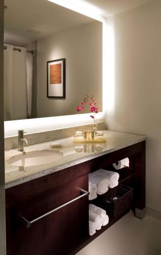 a bathroom with a sink and a mirror and towels at Hyatt Regency Suites Atlanta Northwest in Atlanta