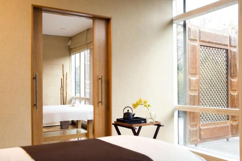 1 dormitorio con espejo, cama y ventana en Park Hyatt Mendoza Hotel, Casino & Spa en Mendoza