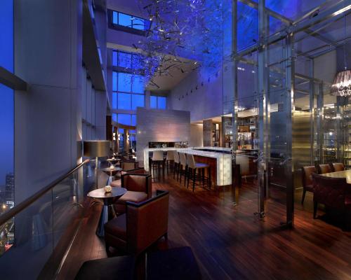 a restaurant with a bar and some tables and chairs at Grand Hyatt Shenzhen in Shenzhen