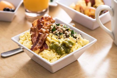 a bowl of scrambled eggs with bacon and other food at Hyatt Place Daytona Beach-Oceanfront in Daytona Beach