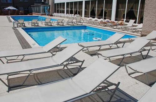grupa leżaków i basen w obiekcie Baltic Inn w Pogorzelicy