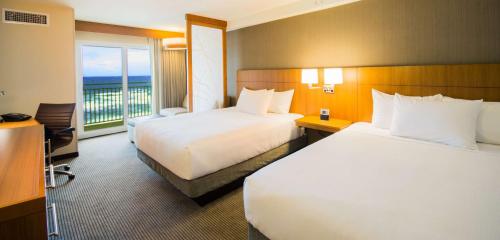 a hotel room with two beds and a balcony at Hyatt Place Daytona Beach-Oceanfront in Daytona Beach