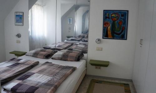 a room with three beds in it with a painting on the wall at BodenSEE Apartment 1 - 4 Meersburg Daisendorf in Daisendorf