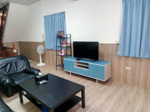 a living room with a couch and a tv on a table at Traveler Station in Kaohsiung