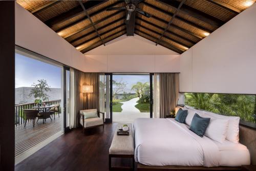 a bedroom in a villa with a bed and a balcony at Alta Vista Mountain Villa Bali in Gitgit