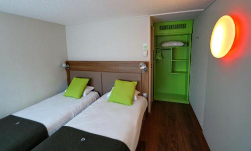 2 łóżka w pokoju zielonym i białym w obiekcie Campanile Albi Centre w mieście Albi