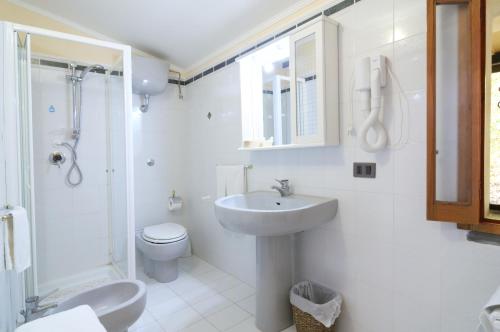 a white bathroom with a sink and a toilet at Hotel Villa La Colombaia in Agropoli