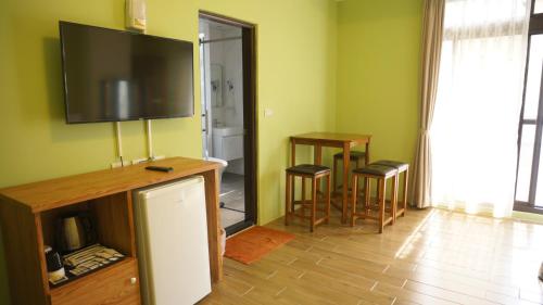 a living room with a flat screen tv on the wall at Warm Breeze Stay in Hualien City