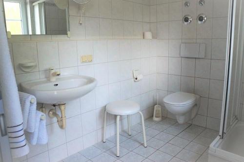 a white bathroom with a sink and a toilet at BodenSEE Apartment 1 - 4 Meersburg Daisendorf in Daisendorf
