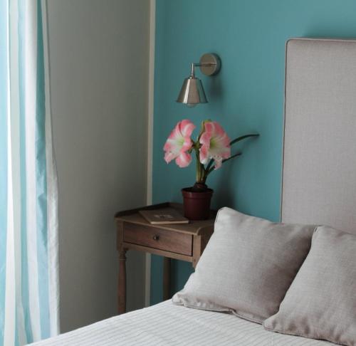 a bed with a table with a lamp and a flower on it at B&B Le Biciclette in San Vito lo Capo