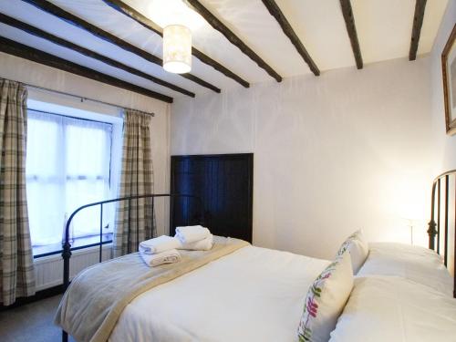 a bedroom with two beds and a window at Laurel Cottage in Ulverston