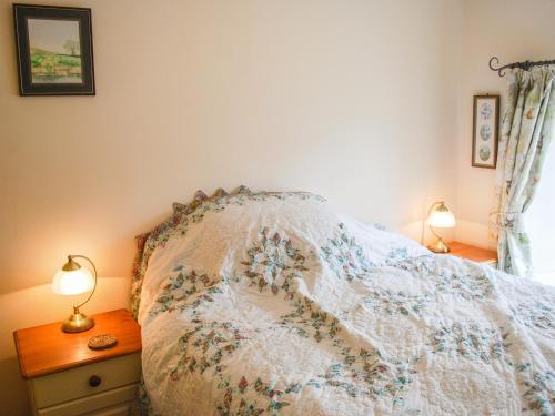 Un dormitorio con una cama con una manta. en Cartmel Cottage en Leyburn