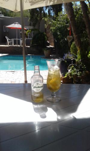 a drink sitting on a table near a pool at @Echeveria in Montagu