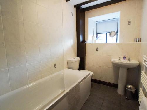La salle de bains est pourvue d'une baignoire, de toilettes et d'un lavabo. dans l'établissement Laurel Cottage, à Ulverston