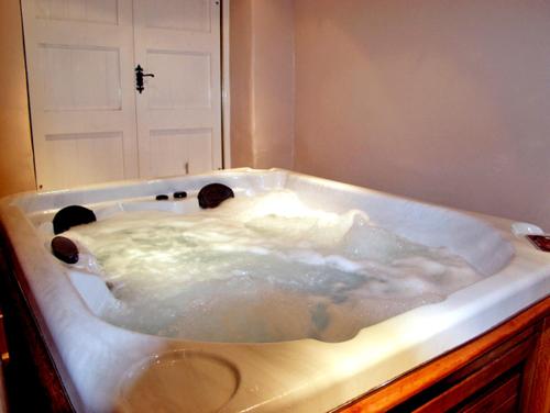 a bath tub filled with water in a bathroom at The Loft in Dronfield