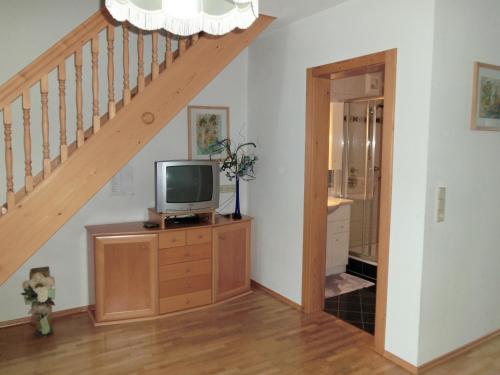 a room with a tv on a dresser with a staircase at Obergarberhof in Sillian