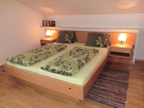 a large bed in a room with two night stands at Obergarberhof in Sillian