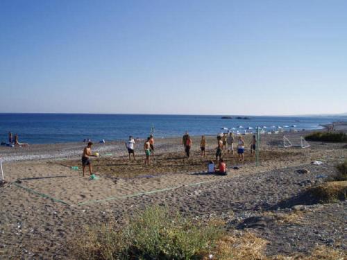 a group of people standing on a beach at Seaside Studios Kirania in Kiotari