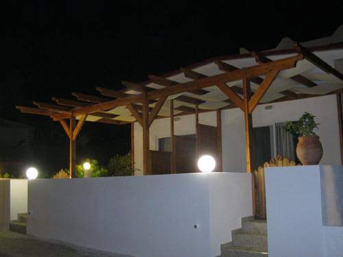 a white wall with a wooden pergola at night at Seaside Studios Kirania in Kiotari