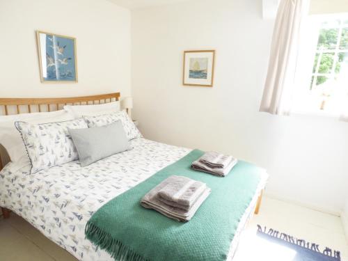 a bedroom with a bed with two towels on it at Corner Cottage in Amble