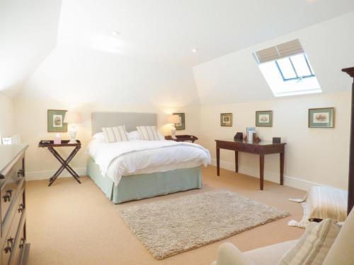 1 dormitorio con cama, escritorio y ventana en Farm Cottage en Saint Erth