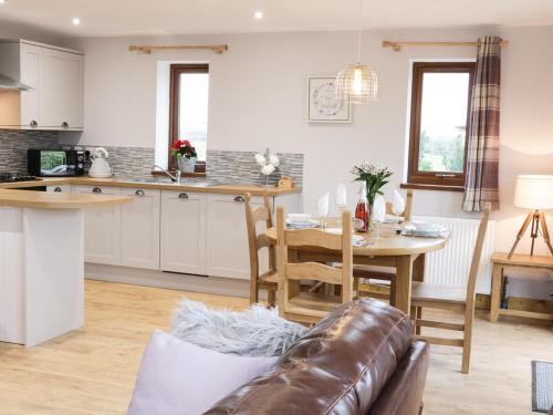 a kitchen and living room with a couch and a table at Gardener's Lodge in Nantwich