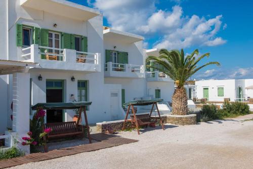 a white building with a palm tree in front of it at Arhontou in Apollonia