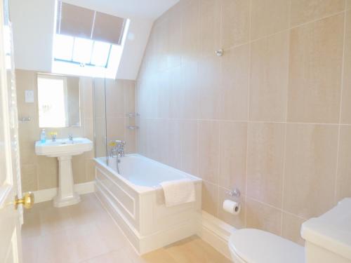 a bathroom with a tub and a sink and a toilet at Farm Cottage in Saint Erth