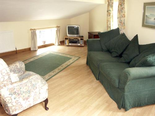 a living room with a couch and a chair at The Coach House in Hereford
